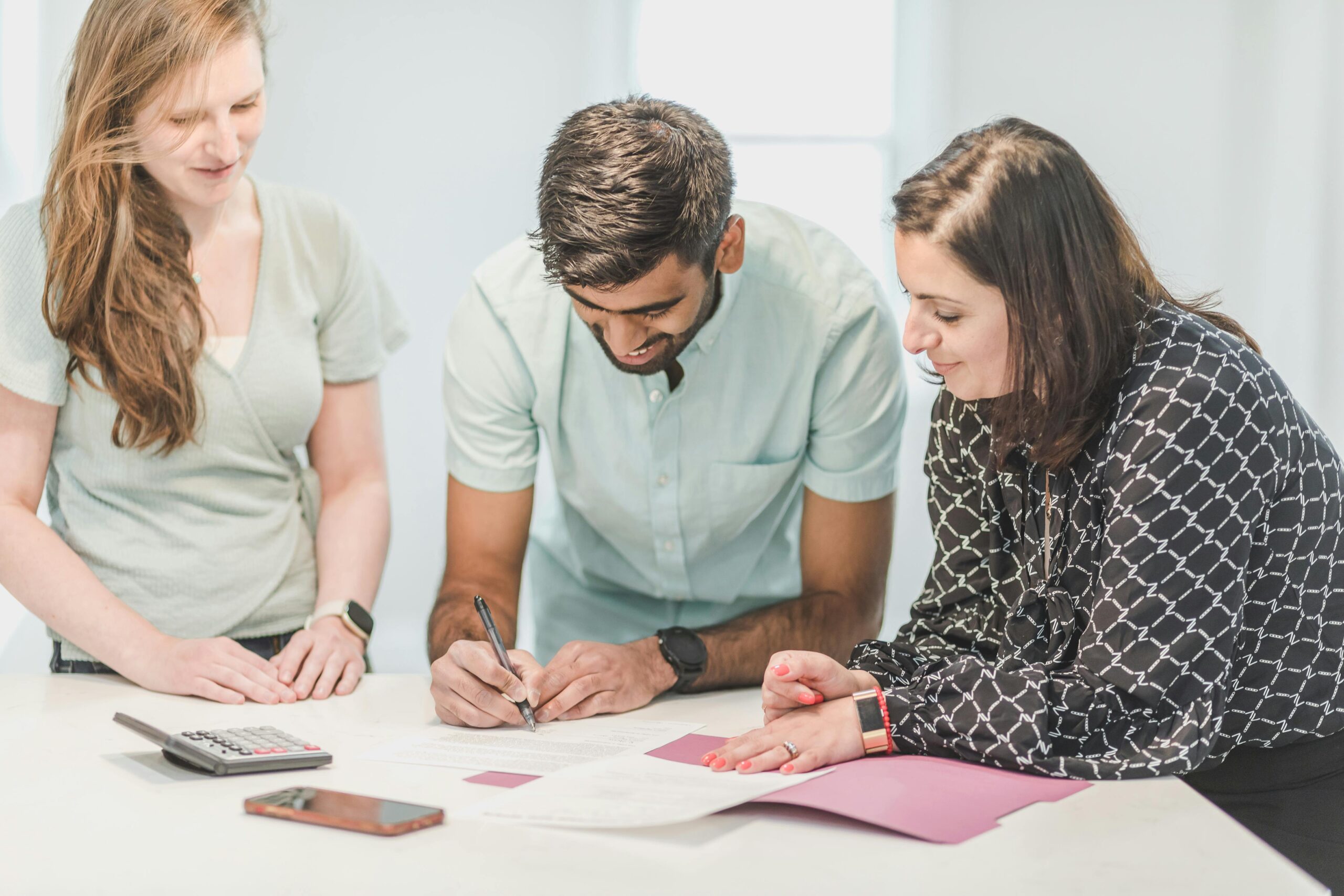 couple signing paperwork with a real estate agent